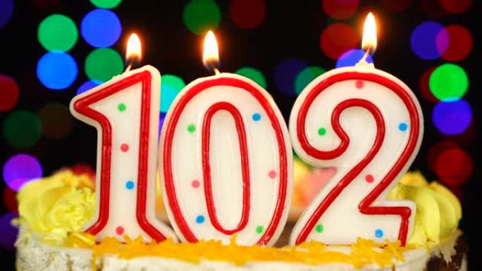 102号生日快乐蛋糕与燃烧的蜡烛顶。