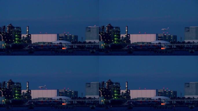 黄昏时炼油厂的景色。客机着陆。
