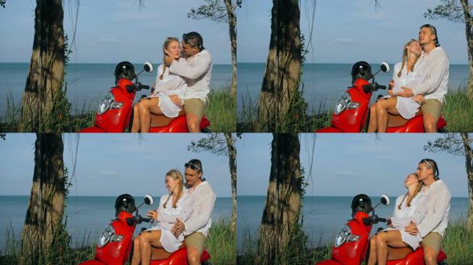 在森林之路之旅中，穿着白色衣服的红色摩托车上的爱情情侣。两个白人旅游男女亲吻拥抱坐在踏板车上。