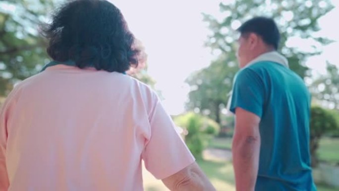 老年亚洲夫妇一起在公园里散步，家人聚在一起，牵手爱的结合，人际关系，退休生活方式，老年人心理身体健康
