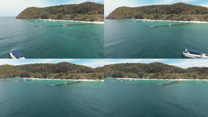 泰国Koh Hey (珊瑚岛) 的水晶般清澈的异国水域，带有浮动平台码头-空中低角度轨道调查拍摄
