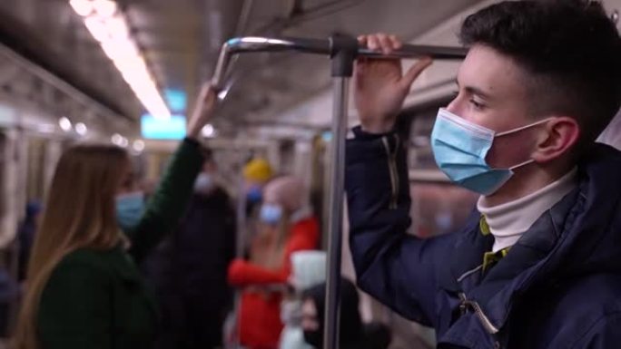 戴着口罩的高个子年轻人乘坐地铁