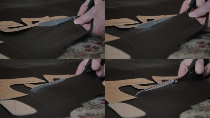 特写的一个主人的手一厢情愿的人，一个皮匠削减天然皮革与剪刀在车间制作手工产品。制作手工皮革制品