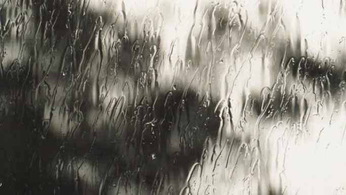 雨水中的滴水流过窗户。