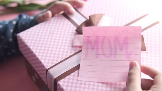母亲节概念儿童手捧粉色礼品盒