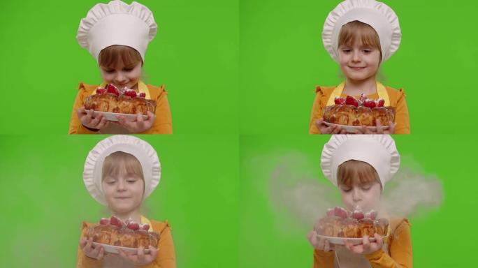 扮成厨师厨师的女童儿童在草莓蛋糕上撒上糖霜，色度关键背景