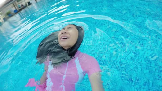 快乐的亚洲女孩漂浮在游泳池的水上，生活方式理念。
