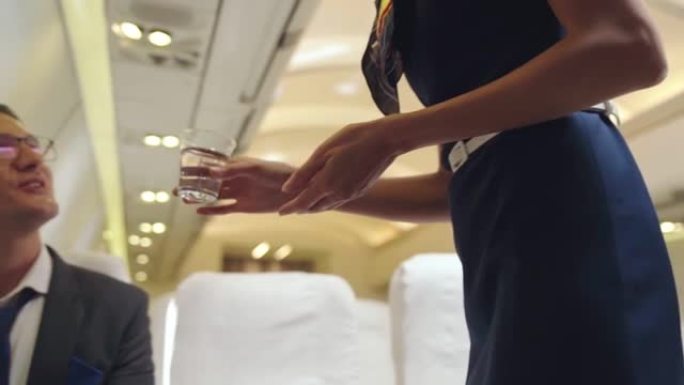 空乘人员在飞机上为乘客提供水