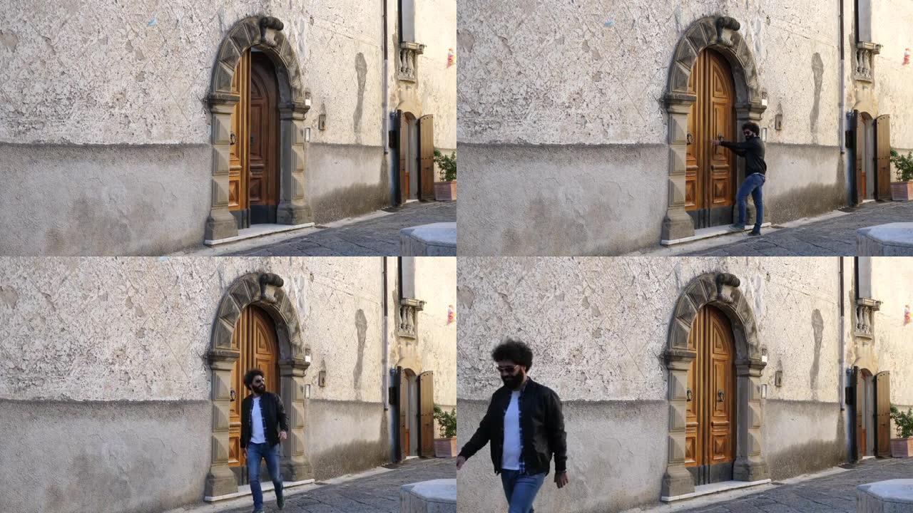 黑色卷发的男人从意大利南部的一扇古老的门出来。