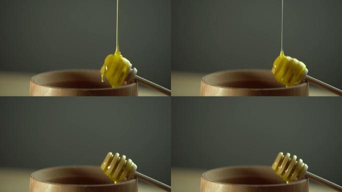 从勺子里滴下浓稠的蜂蜜，特写。从勺子里流出蜂蜜的蜂蜜