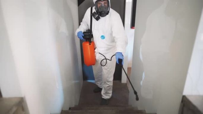 冠状病毒大流行期间穿着防护服消毒楼梯的环卫工人