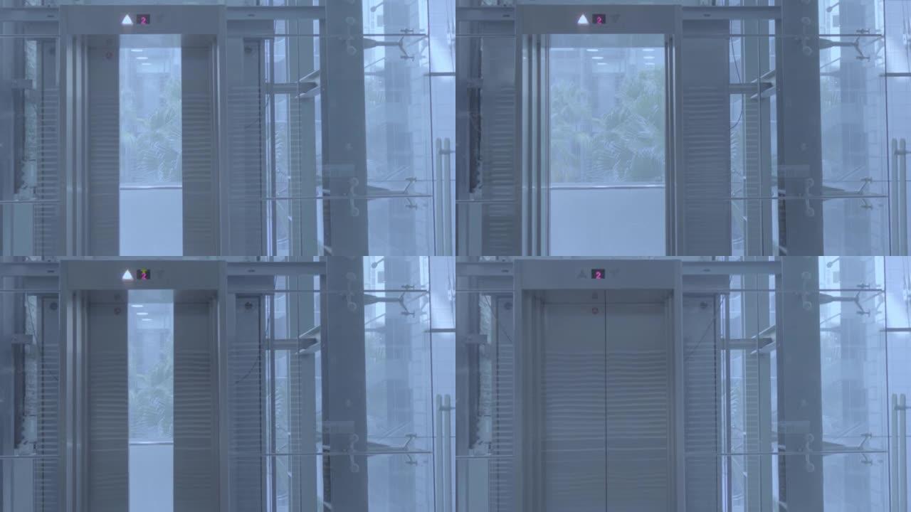 现代商业建筑中的移动电梯。电梯从一楼上升到二楼。开门后，在二楼停车。主题在左边。