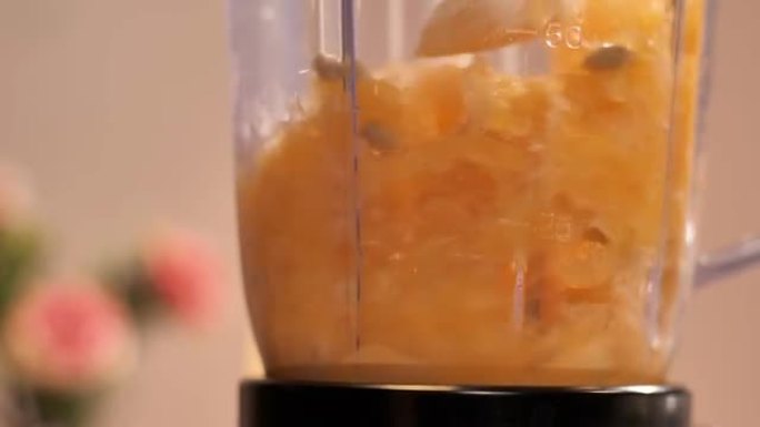 大量的橙片搅拌成透明的榨汁机搅拌机罐子-热带水果