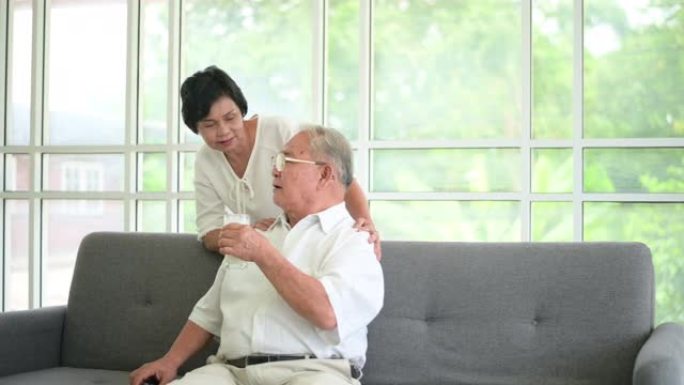 幸福的老年夫妇喝牛奶，在家里共度时光，健康和退休理念
