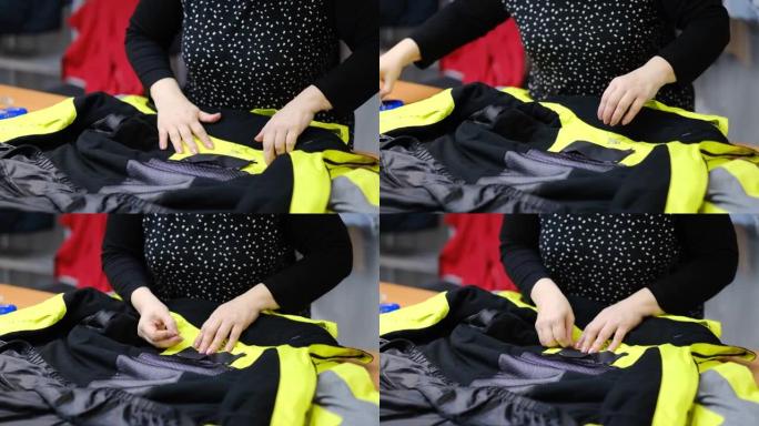 才华横溢的女裁缝师用纺织品缝制衣服。缝纫过程的特写视图。光线模糊背景