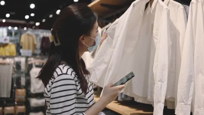 covid疫情后的新常态扬德亚洲女性戴口罩防护购物裙或布在精品店购物商场的新生活方式背景
