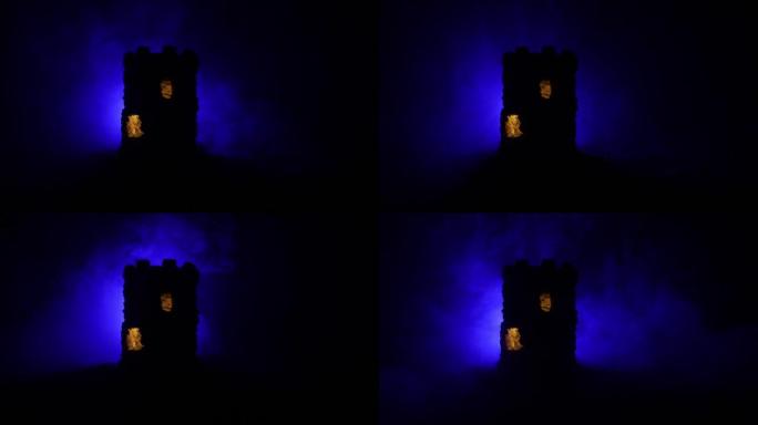 晚上的石头防御塔。中世纪城堡微型，带色调雾背光。创意餐桌装饰。选择性聚焦