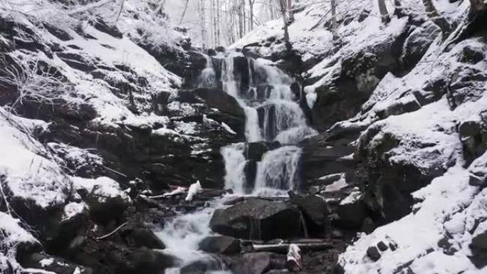 山区的冬季瀑布。水冲破冰雪