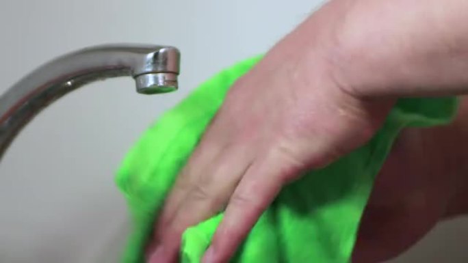 男人的手用绿色毛巾擦干。