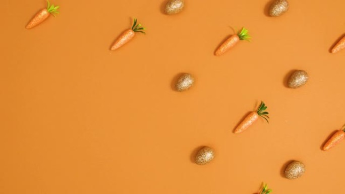 复活节闪光蛋和胡萝卜在橙色背景上形成创意图案。停止运动