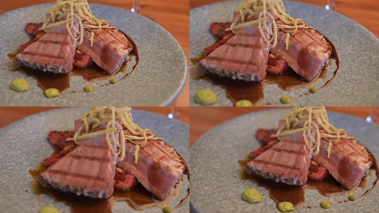 金枪鱼鱼片，在马莫尔盘子里有烤制的金丝菊。金枪鱼鱼片和红酒杯