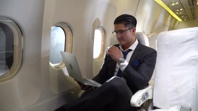 商人坐在装有阳光的飞机上的笔记本电脑上