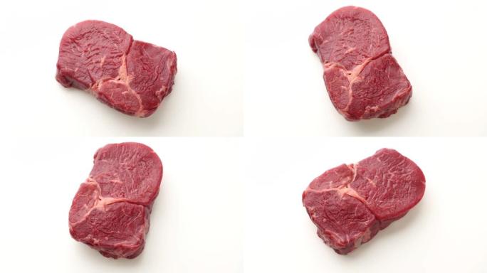 在白色背景上翻转生牛肉牛排肉的特写镜头，顶视图