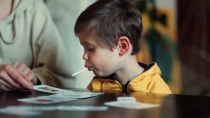 小男孩在餐桌旁的ABA治疗计划下从卡片上学习单词