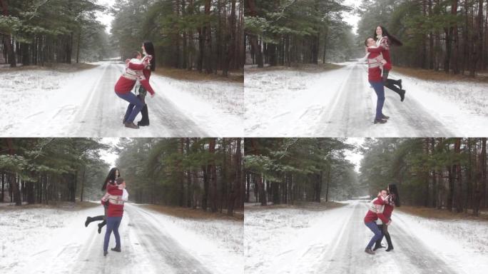 一对穿着红色圣诞毛衣的情侣在白雪皑皑的冬季森林中旋转