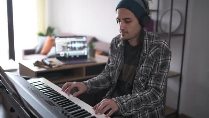 新型冠状病毒肺炎大流行期间，男音乐家在家弹钢琴/作曲。
