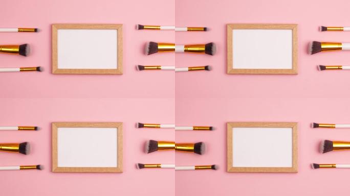 停止运动动画模型木制相框顶部视图化妆刷设置在粉红色背景上。化妆品和美容概念模板。用复制空间平铺构成概