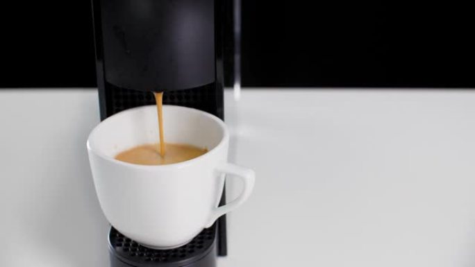 关闭将热浓缩咖啡和蒸汽从咖啡机倒入咖啡馆的白杯。现代机器专业咖啡冲泡，倒入瓷杯。