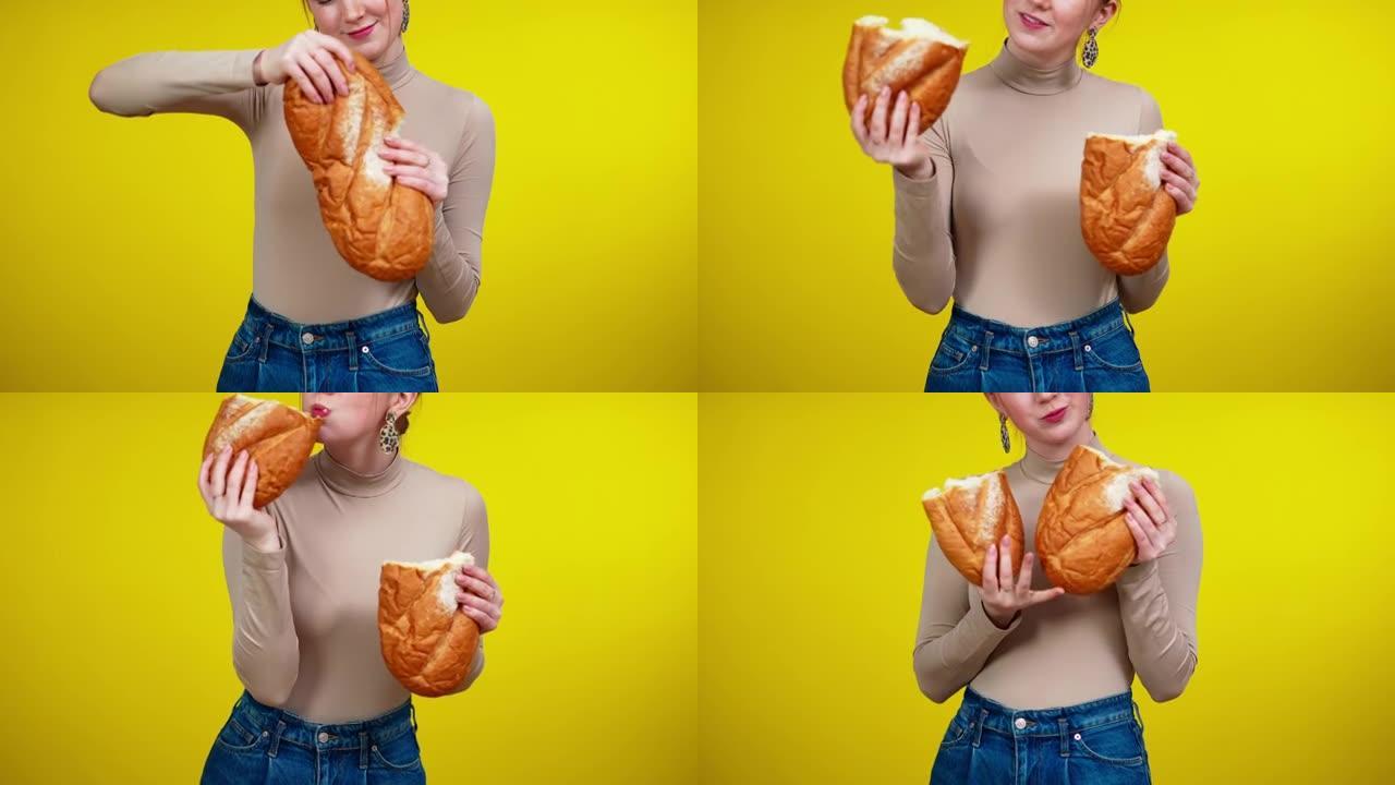 面目全非的年轻苗条女人撕着面包，吃美味的面包店。白人红发女士在黄色背景下享受美味的乡村糕点