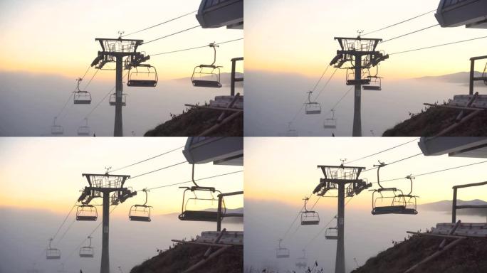 日落时分，升降椅在清澈的山顶上移动，从薄雾中升级。乌克兰喀尔巴阡山脉布科维尔滑雪胜地的雾天