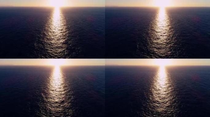 鸟瞰图，一艘帆船的无人机在日落下在地中海中部航行。我们可以看到整个地平线上的船和水以及水中光线的反射