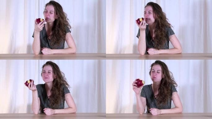 女人正在吃美味的红苹果。年轻女孩正在吃水果。课堂和快乐。