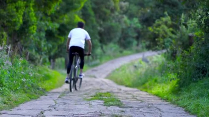 拉丁男子伸展肌肉，然后上自行车，他可以用自行车运输和运动。平均年龄25岁的拉丁男子穿着运动服正在伸展
