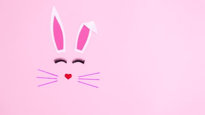 复活节兔子在柔和的粉红色背景上闪烁着睫毛。停止运动flay lay动画