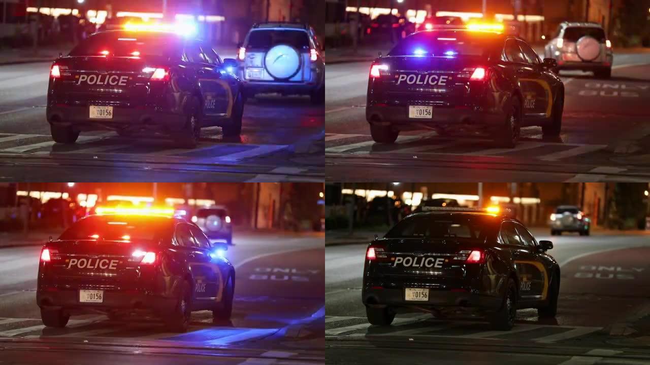 巴尔的摩市街道和夜间警用车灯。警察在公交专线上拦下了不知名的车辆。马里兰州