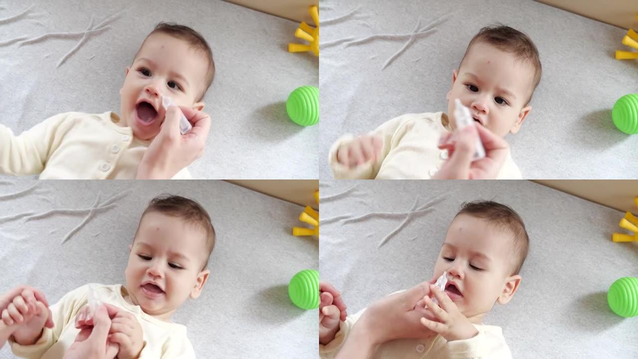 用滴鼻剂给婴儿的女人。婴儿鼻腔滴注。女婴因为生病和流眼泪而哭泣。慢动作