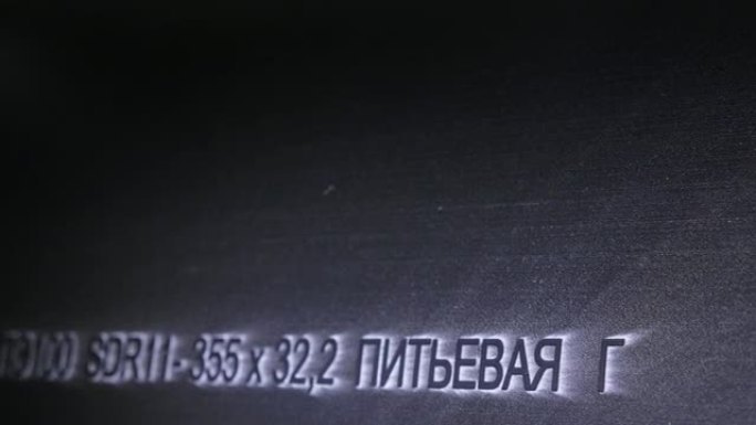 激光打标机雕刻。塑料水管制造厂。利用水和气压在机床上制作塑料管的过程。