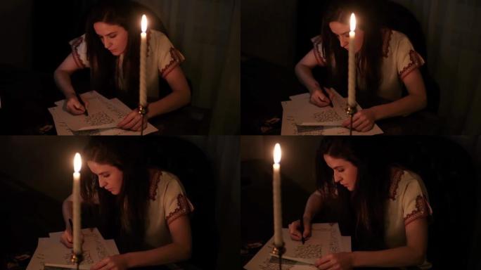 穿着睡衣的作家女人在烛光的黑暗房间里写诗