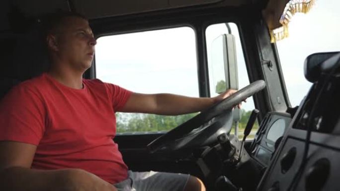 卡车司机将手臂放在方向盘上，并控制卡车行驶到目的地。男子在夏日驾驶汽车穿越乡村。卡车司机在乡间道行驶