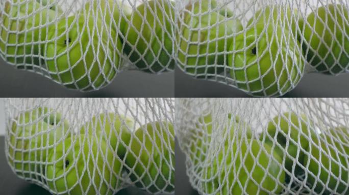 用大青苹果拍摄的蔬菜和水果白网的特写镜头。网格中有四个苹果。健康饮食。水果有用性概念