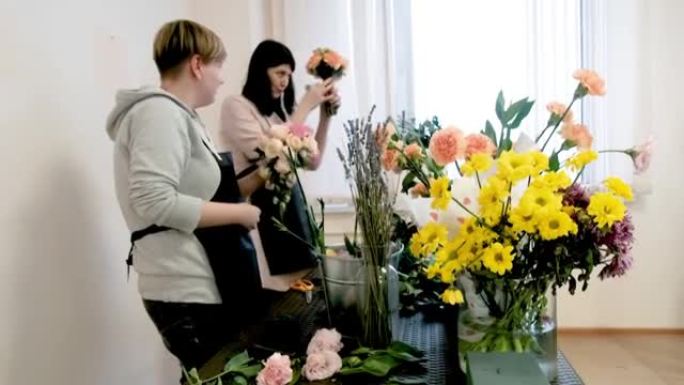 一群女性花店制作花卉设计。组。年轻专业人士制作美丽花束的做法。在花店工作。为假期、婚礼、周年纪念日做