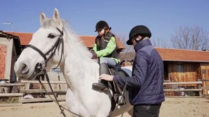兴奋的女孩，在参观动物救援中心时学习如何骑马
