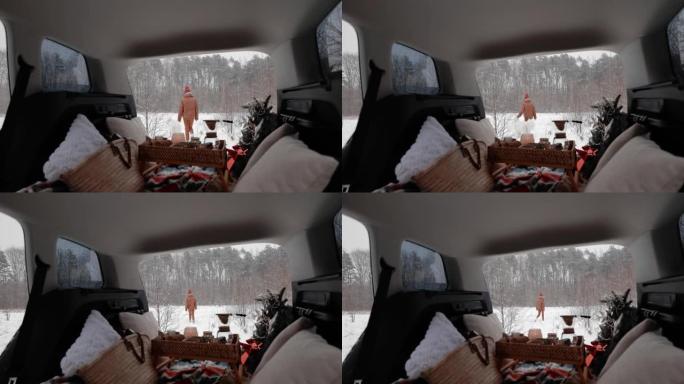 女人在白雪皑皑的森林上与狗一起开车旅行