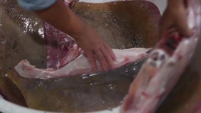 将黄貂鱼 (rays鱼) 斩首成碎片，在鱼市场上出售