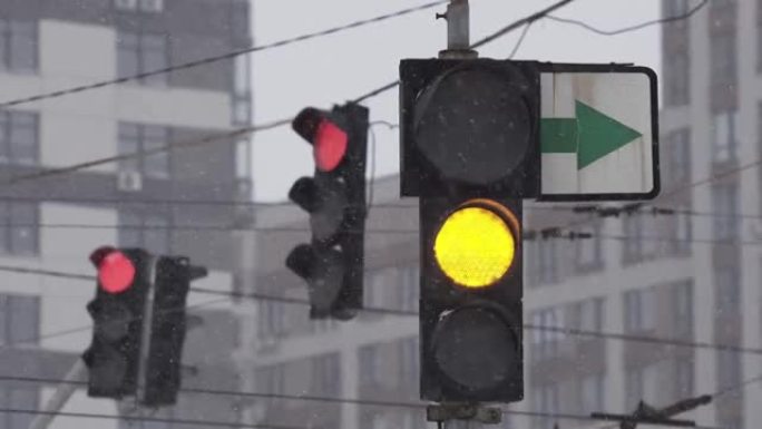下雪的冬日，城市街道上的交通信号灯。特写。绿色关闭，红色打开。暴风雪期间的道路交通。困难路况下的行车