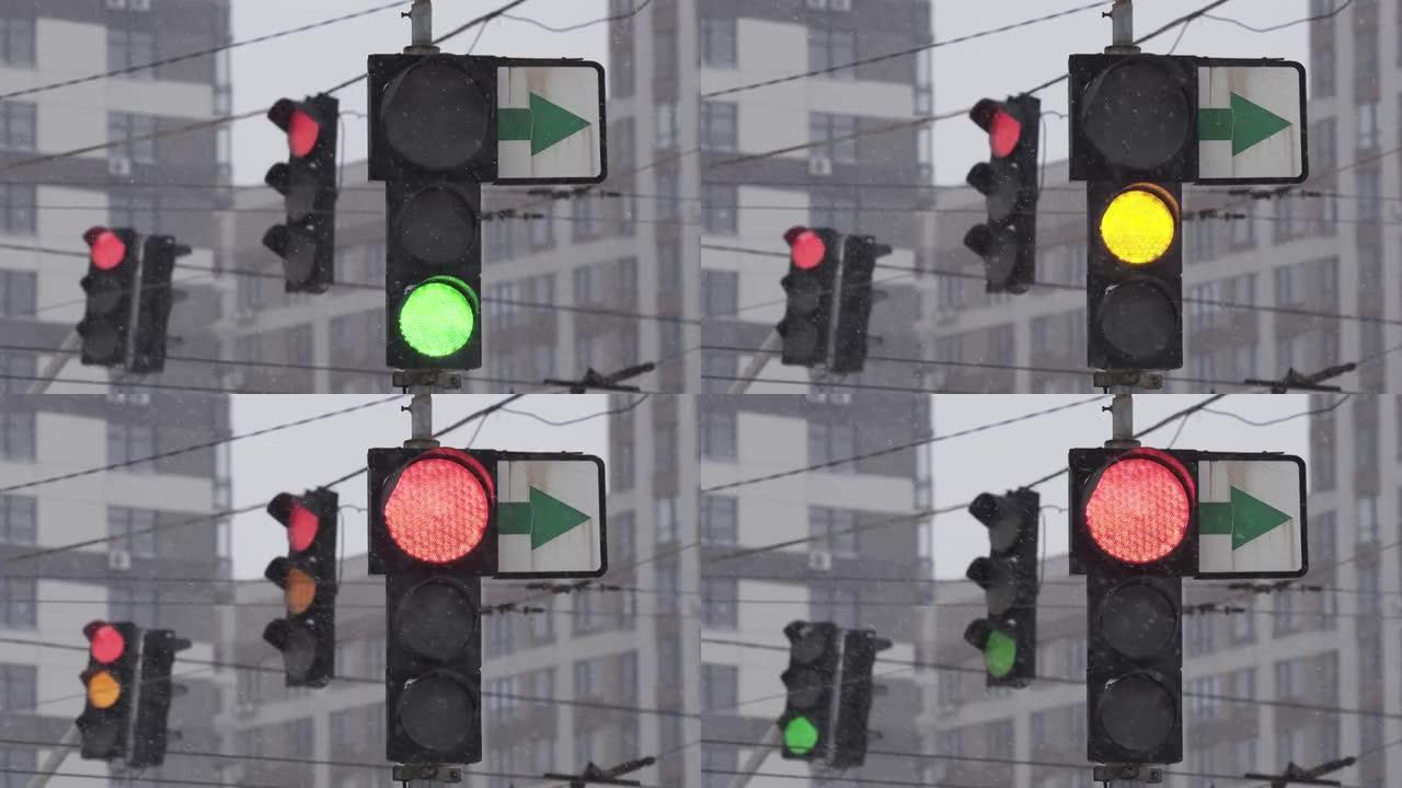 下雪的冬日，城市街道上的交通信号灯。特写。绿色关闭，红色打开。暴风雪期间的道路交通。困难路况下的行车